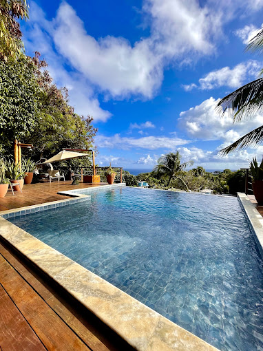 Piscina da pousada com deck de madeira e vista para o mar de Fernando de Noronha